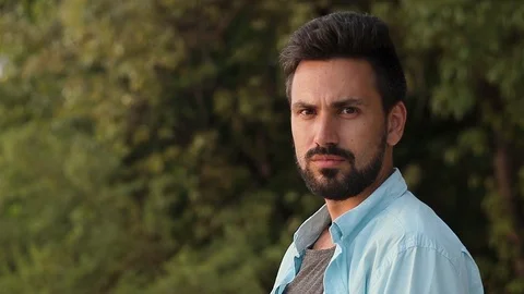 Portrait of a young handsome man with a beard. Looking at the camera. Stock Footage 99892458