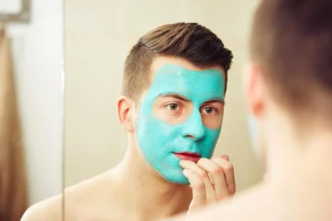 Portrait of young handsome man with facial mask. 写真素材