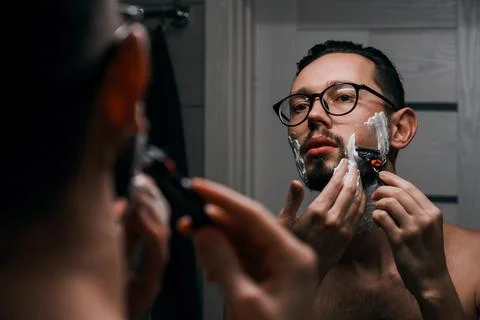 Portrait of a young handsome man with glasses shaves Foto stock