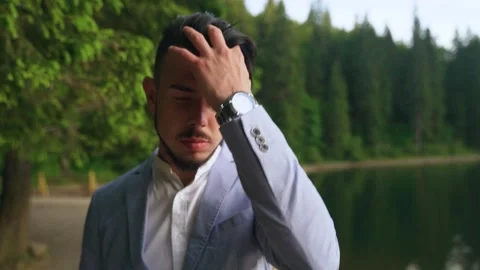 Portrait of a young handsome man touching his hair and fixing it. Slow motion Stock Footage 211807013
