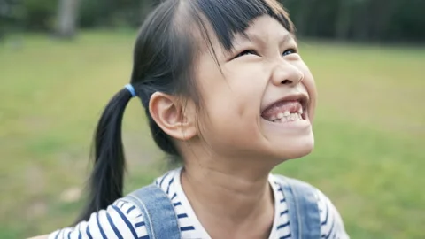Portrait of young happy asian little girl have fun in the park. Close up smile. Stock Footage 219856464