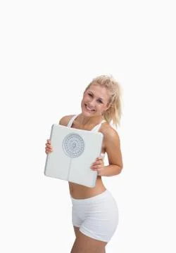 Portrait of young happy woman holding weighing scales Stock Photos