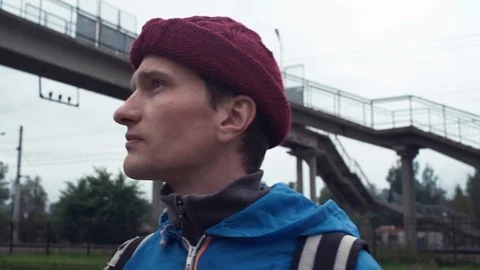 Portrait of young hiker with backpack standing on railway station Stock Footage 80054688