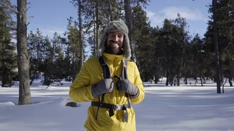 Portrait of a young hiker looking directly into the camera near a snowy mountain Stock Footage 169718075