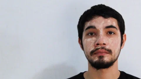 Portrait of young Hispanic man with a beard wearing a hydrating mask Video stock 126947762