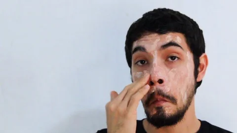 Portrait of young Hispanic man with a beard wearing a hydrating mask Video stock 126948854