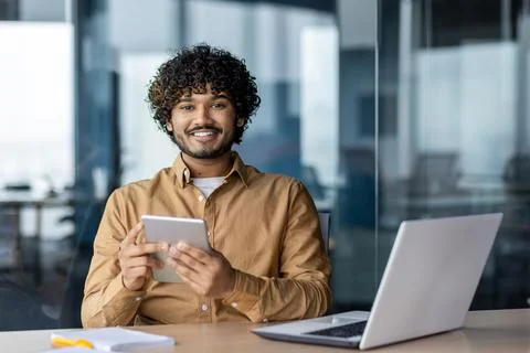 Portrait of young Indian programmer, man working inside company office, using Stock-Fotos