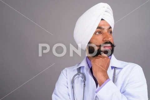 Portrait of young Indian Sikh man doctor thinking Stock Photos