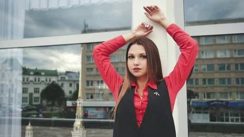 Portrait of young lady in front of mirrored shop windows, looking at camera. Stock Footage 80789171
