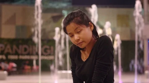 Portrait of young lady sitting in front of fountain 4k UHD (3840x2160) Stock Footage 78809976