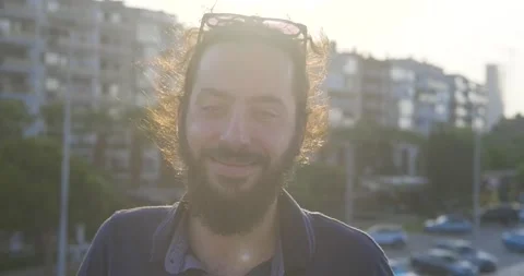Portrait of young, long haired and bearded hipster guy on sunshine. Smiling s Stock Footage 139298722