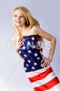 Portrait of young lovely lady with blond hair wearing american flag as dress Stock-Fotos