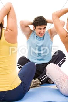 Portrait of young male instructor showing physical exercise to girls Stock Photos