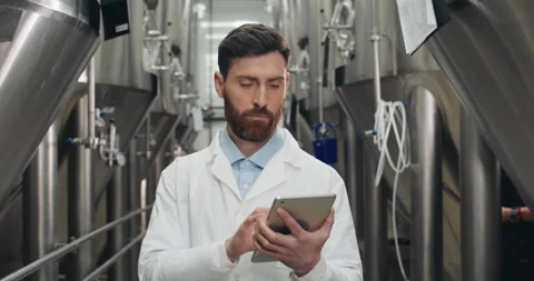 Portrait of young male process engineer entering data on tablet at brewery. Man Stock Footage 130997852