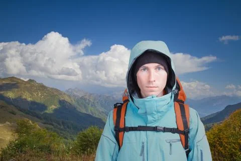 Portrait of young man with backpack on the background of a mountain landscape Stock Photos