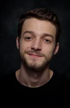 Portrait of a young man with a beard on a dark background. Stock Photos