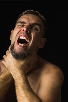 Portrait of young man with beard, hands around throat, screaming. Person hold Stock Photos