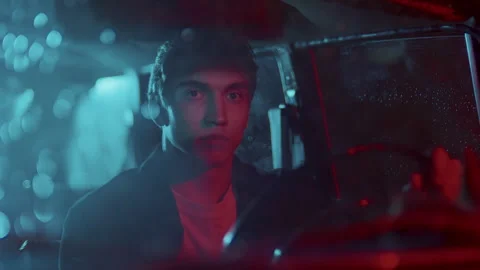 Portrait of Young Man behind Steering Wheel in Car at Night Stock Footage 307551795