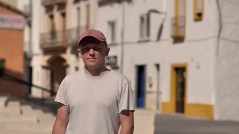 Portrait of a young man in a cap, stands on the street Video stock 120938371