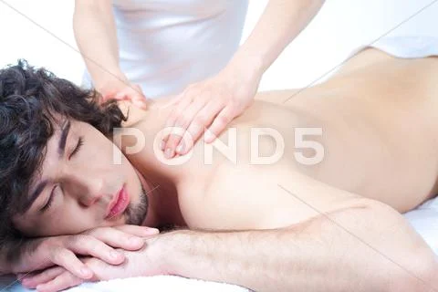 Portrait of young man with closed eyes and getting a relax massage Stock Photos