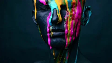 Portrait of young man with colored face paint yellow Stock Footage 148326163
