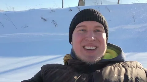 Portrait of a young man coming down the mountain in winter, smiling and looking Stock Footage 60638743