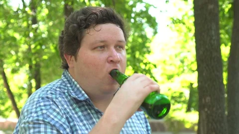 Portrait of young man drinking beer at outdoor park in summer. Stock Footage 95614985