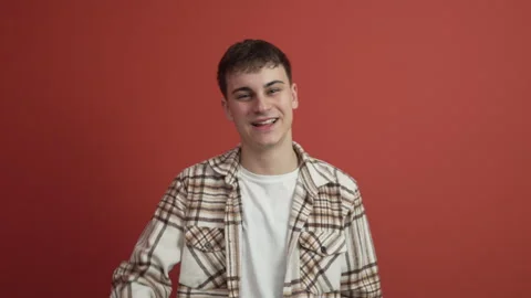 Portrait of young man gesture in front red background studio shot Stock Footage 300789517