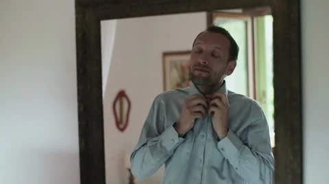 Portrait of young man getting ready, dressing up and looking at mirror Vidéo 12469477