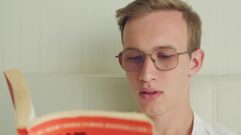 Portrait of a young man with glasses reading a book. Stock Footage 334848443
