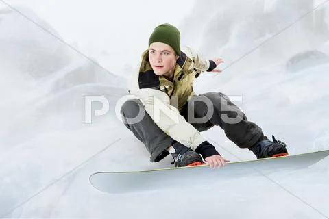 Portrait of young man going in for snowboarding in winter Stock Photos