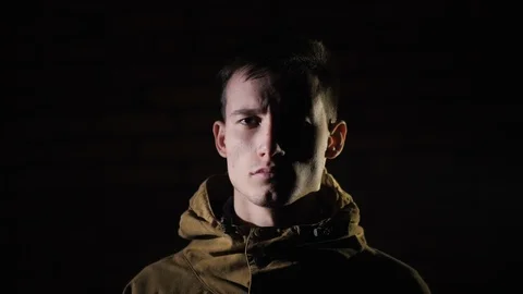 Portrait of a young man in hard light on black background 動画素材 121510555