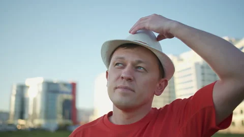 Portrait of a young man in a hat, stands on the street, tracking the camera Stock Footage 145693429