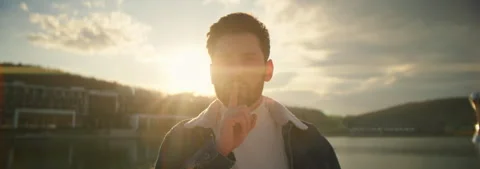 Portrait young man look at camera shows gestures silence. In the background Stock Footage 252139757