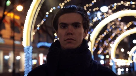Portrait of young man looking at camera standing at night in city Stock Footage 83630000