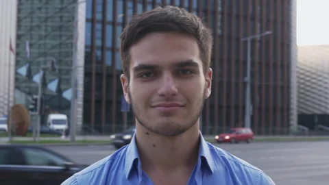 Portrait of young man looking at the camera near the busy street Video stock 133102787