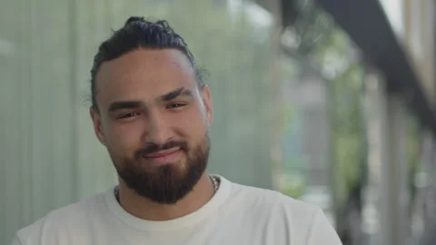 Portrait of a young man looking at the camera with a satisfied face and smiling Stock Footage 249952406