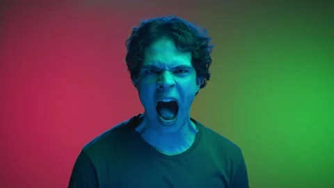 Portrait of Young Man Looking at Camera and Screaming in Neon Lighting of Studio Video stock 254465787