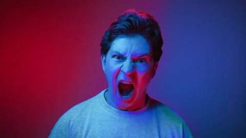 Portrait of Young Man Looking at Camera and Screaming in Neon Lighting of Studio Vídeos de archivo 255291160
