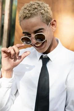 Portrait of young man looking at camera playing with glasses Stock Photos