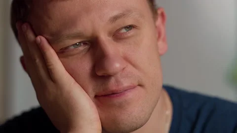 Portrait of a young man looking to the side with a smile, dreaming Stock Footage 143970579