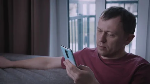 Portrait of a young man, the man is browsing an app on his mobile phone Stock Footage 312746160
