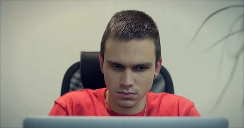 Portrait of Young Man, Programmer or Trader, Sitting in the Office With a Stock Footage 103951476