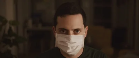Portrait of a young man putting on a protective mask, close up Stock Footage 126341600
