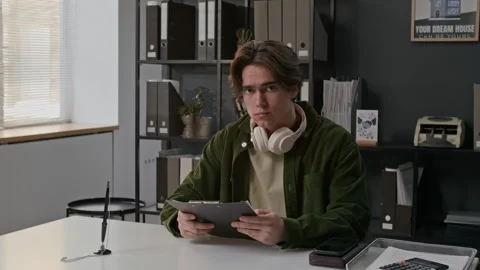 Portrait of Young Man Reviewing Documents at Desk in Bank Office Stock Footage 330956525