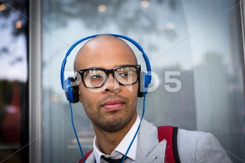 Portrait Of Young Man With Shaved Head Wearing Headphones