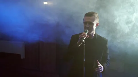 Portrait of a young man singing to microphone Stock Footage 105901900