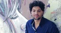 portrait of a young man smiling and laughing leaning against a graffiti wall HD Footage