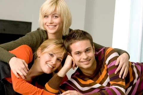 Portrait of a young man smiling with two young women Stock Photos