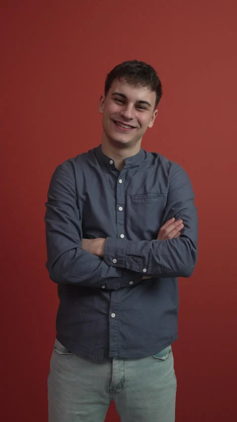 Portrait of young man stand in front red background studio shot Stock Footage 300789495